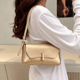 Bolsa Amélia dourada usada no ombro