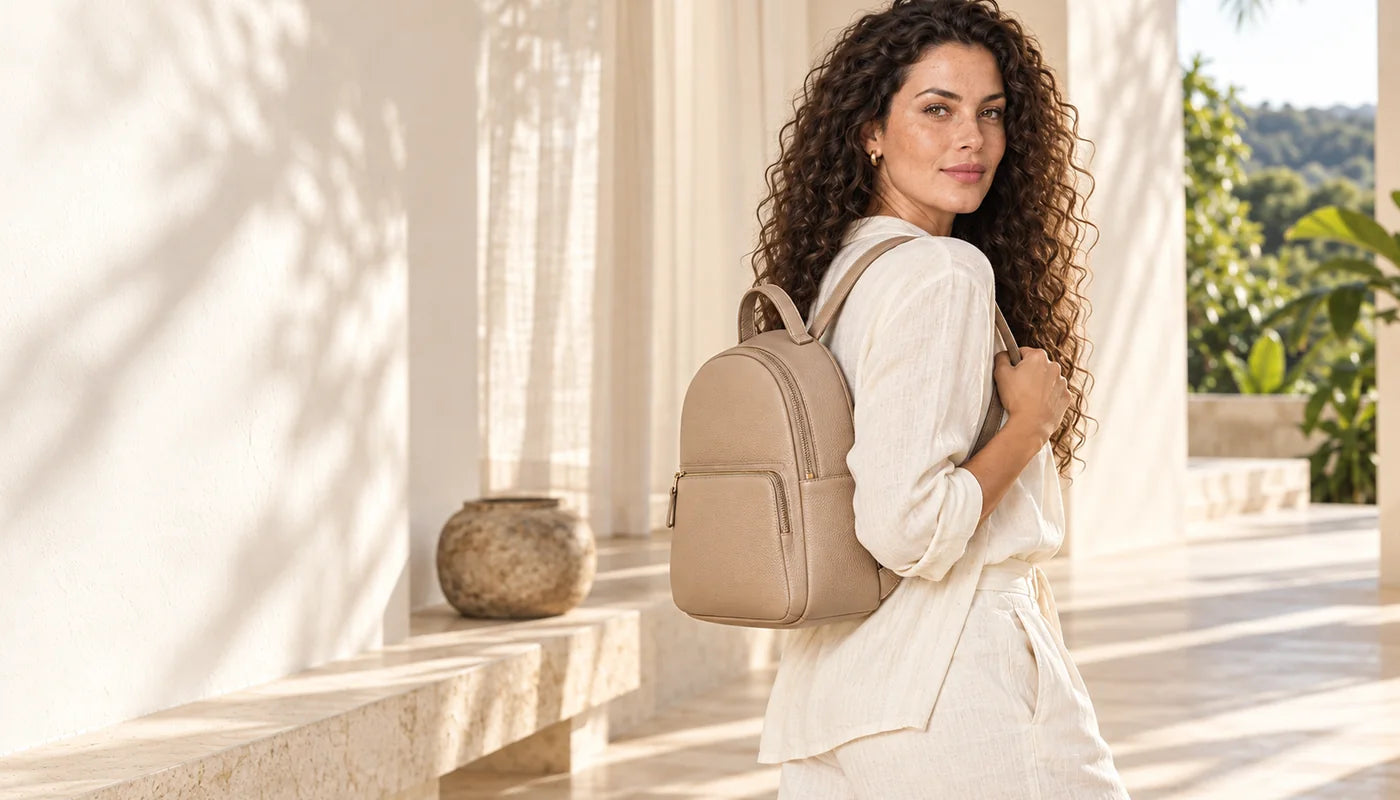 Mulher usando mochila bege em ambiente claro — Aurora Ateliê